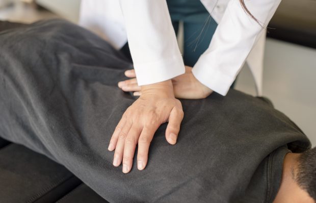 Doctor adjusting young patients back in San Francisco, California, United States