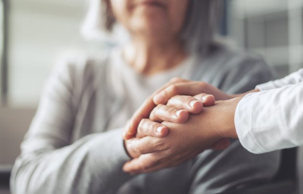 Hands holding old woman's hands